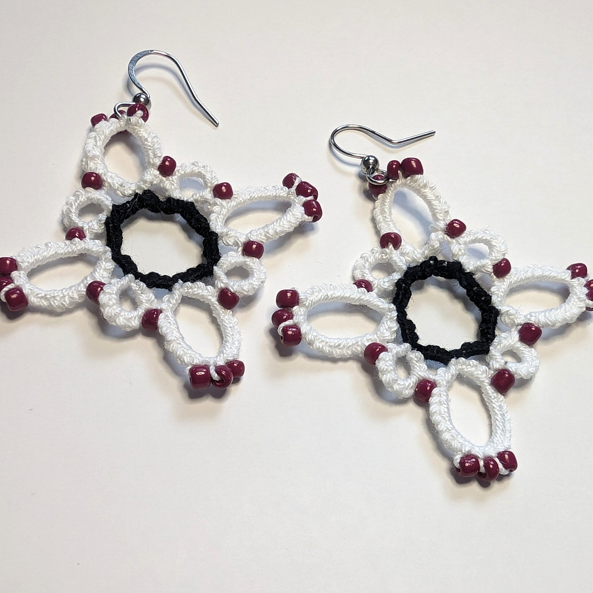 White Black and Maroon Starburst Earrings on White Background