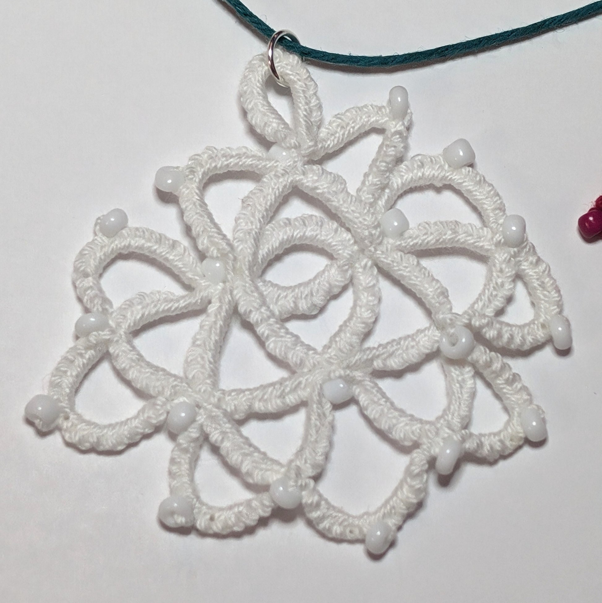 Whites Green Rose Necklace on white background with red bead on edge